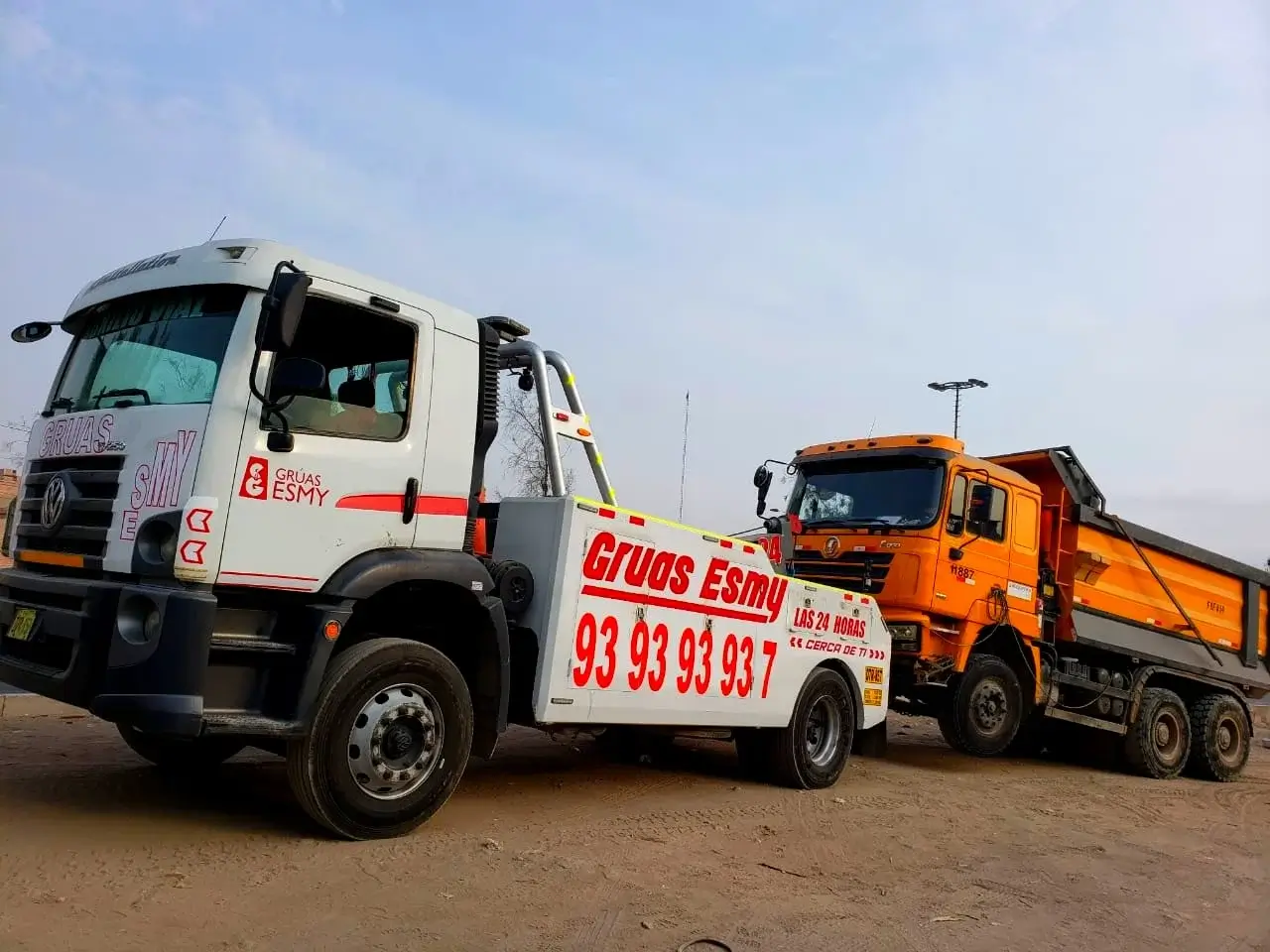 Esmy gruas se encuentra brindando el servicio de asistencia vial a una maquinaria pesada de color naranja en la ciudad de lima centro