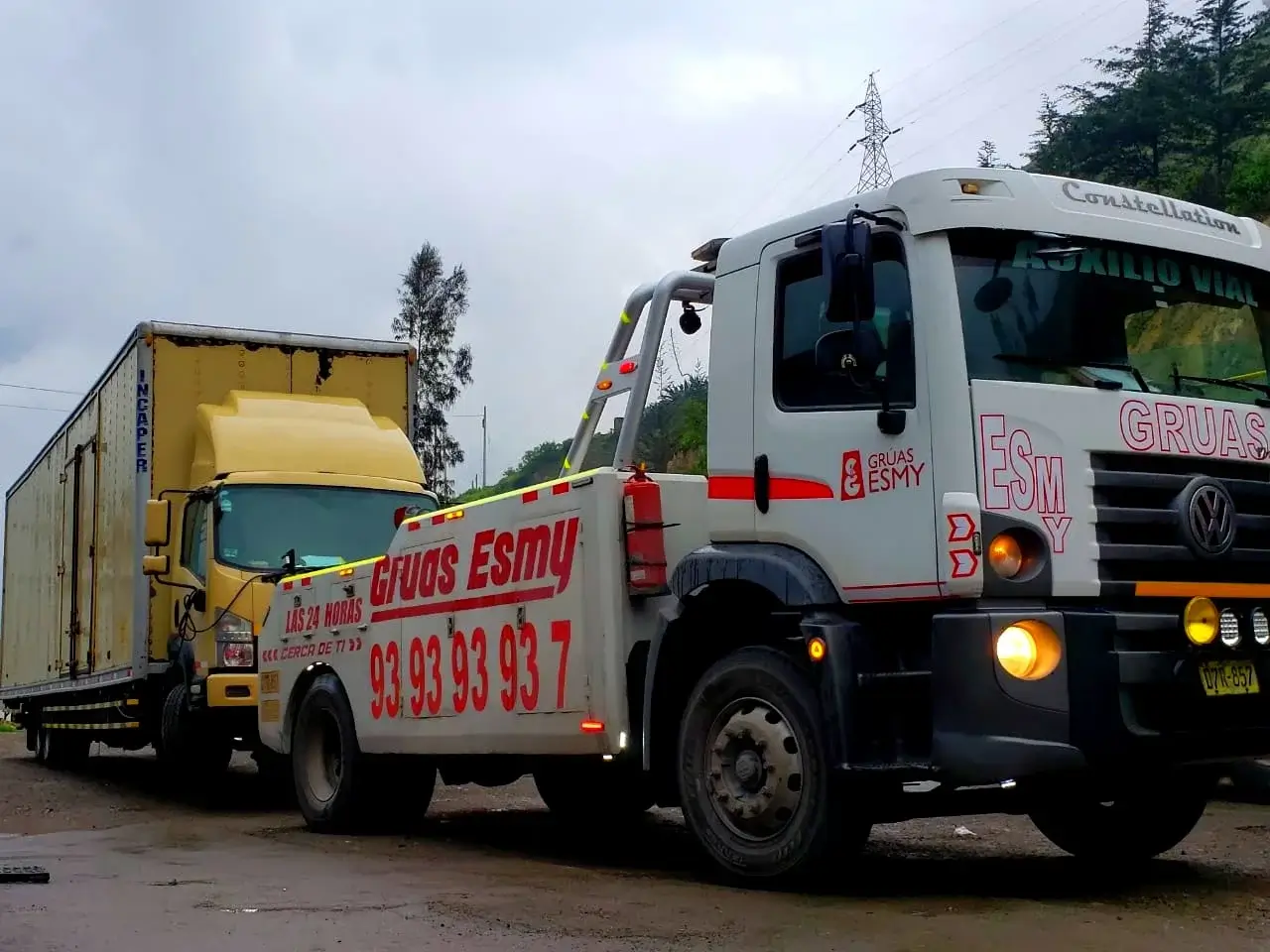 La empresa gruas esmy con cobertura nacional se localiza en pisco ejecutando traslado de un camion pesado amarillo